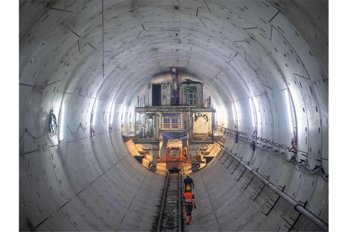 Bauarbeiter laufen im Tunnel zu einem Nachläufer der Tunnelbohrmaschine. Foto: Tom Weller/dpa