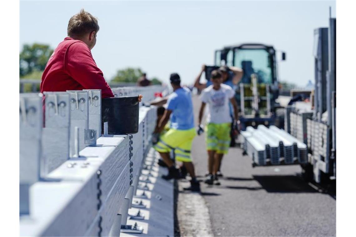 Bauarbeiter montieren im vergangenem Jahr eine Leitplanke auf der Salierbrücke. Foto: Uwe Anspach/dpa/Archivbild