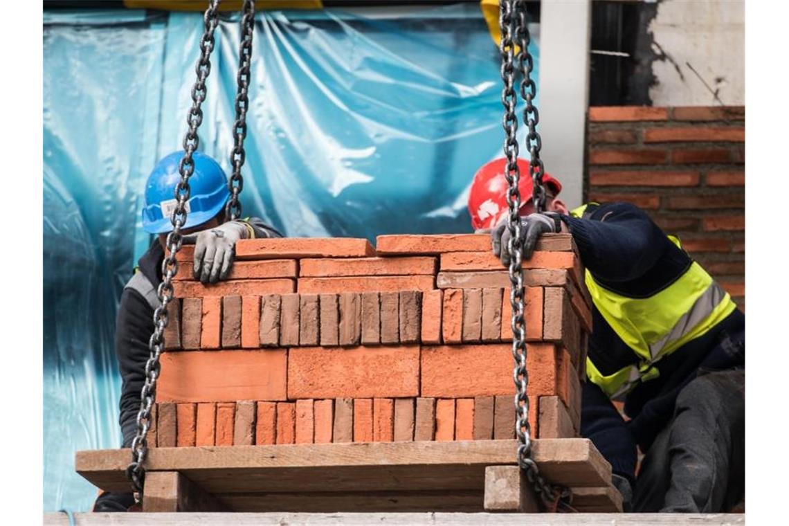 Bauarbeiter setzen eine Palette Backsteine ab. Die Rohstoffknappheit droht den Aufschwung im Handwerk zu gefährden. Foto: Andreas Arnold/dpa