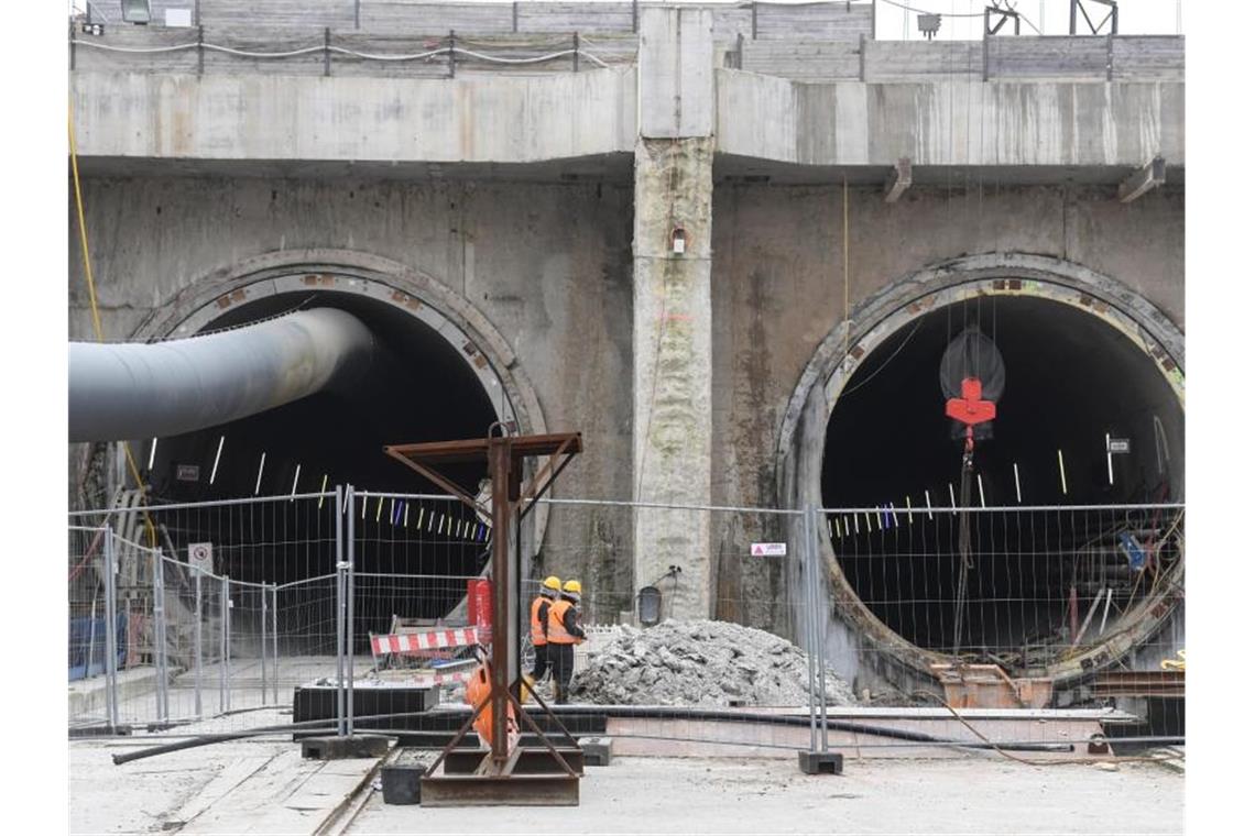 Bauarbeiter stehen vor dem Eingang des Bahntunnels. Foto: Patrick Seeger/dpa/Archivbild