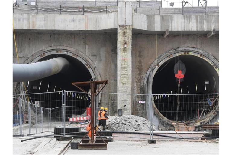 Bauarbeiter stehen vor dem Eingang des Bahntunnels. Foto: Patrick Seeger/dpa/Archivbild