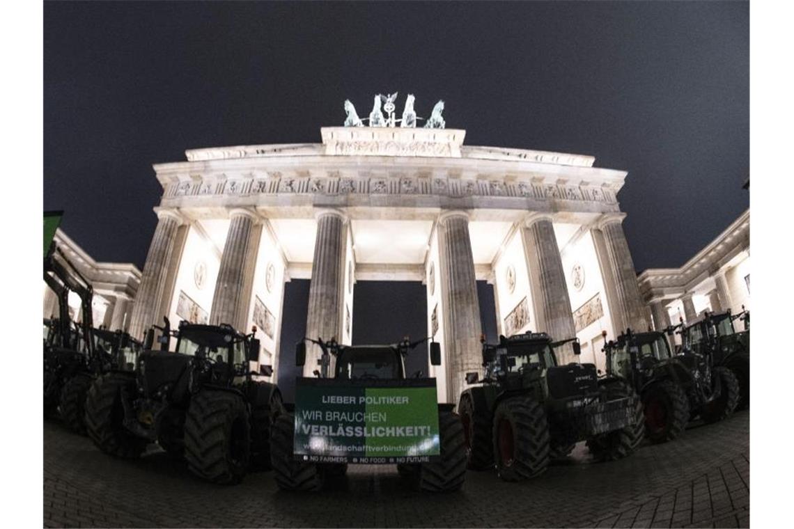 Bauern mit ihren Traktoren stehen vor dem Brandenburger Tor. Foto: Paul Zinken/dpa