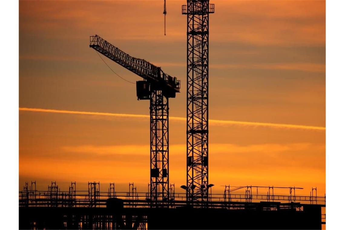 DIHK senkt Konjunkturprognose für 2022 deutlich Baukräne einer Großbaustelle stehen im Sonnenaufgang. Der Deutsche Industrie- und Handelskammertag hat seine Wachstumsprognose für 2022 gesenkt. Foto: Karl-Josef Hildenbrand/dpa