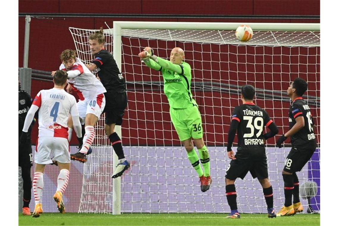 Bayer-Keeper Niklas Lomb (M) wehrt einen Ball ab, hat aber sonst wenig zu tun. Foto: Ina Fassbender/AFP/Pool/dpa