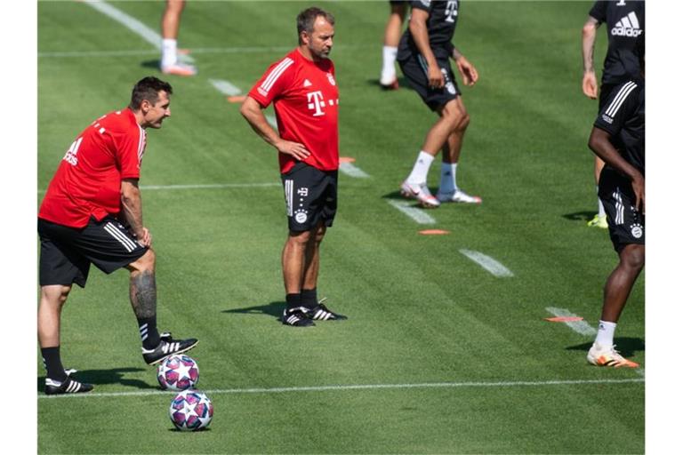 Bayern-Coach Hansi Flick (M) beobachtet seine Spieler beim Training. Foto: Sven Hoppe/dpa