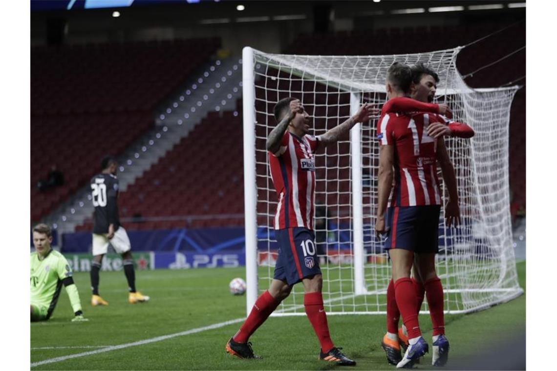 Bayern-Keeper Alexander Nübel (l) sitzt geschlagen am Boden während Joao Felix (r) mit seinen Teamkameraden das 1:0 feiert. Foto: Bernat Armangue/AP/dpa