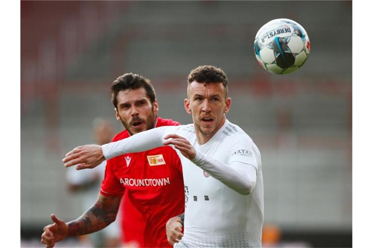 Bayern Münchens Ivan Perisic (r) im Zweikampf mit Unions Christopher Trimmel. Foto: Hannibal Hanschke/Reuters-Pool/dpa