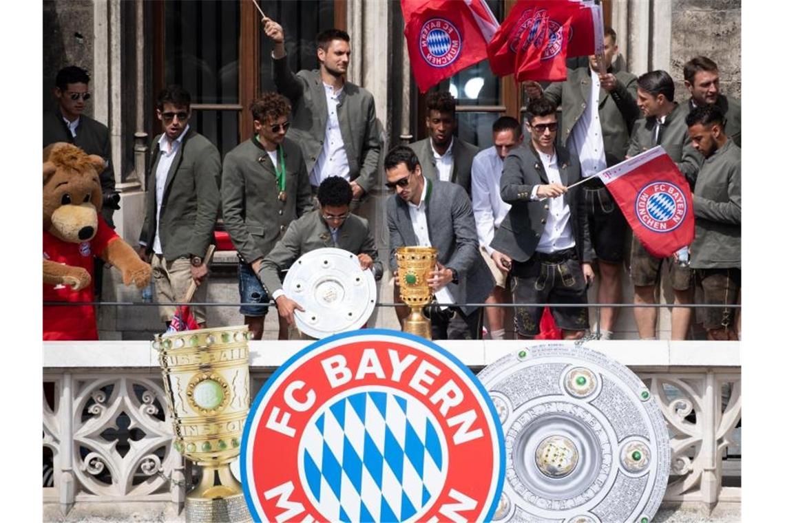 Bayern-Spieler auf dem Balkon des Rathauses am Marienplatz mit der Meisterschale und dem DFB-Pokal. Foto: Sven Hoppe