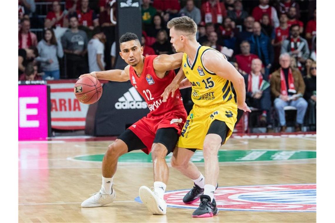 Bayern-Spielmacher Maodo Lo (l) wird von Martin Hermannsson von Alba Berlin verteidigt. Foto: Matthias Balk/dpa