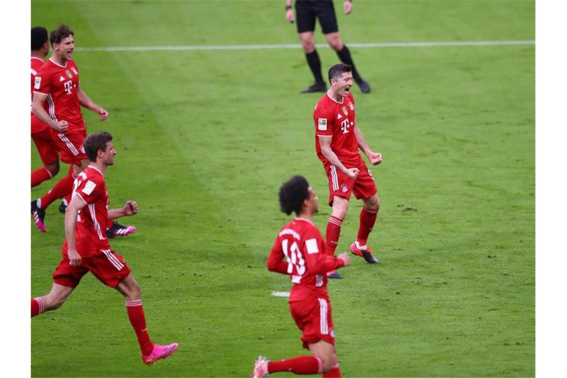 Bayern feiern Titel mit Gala - Lewandowski-Tore 37, 38, 39 Bayern-Stürmer Lewandowski (r) trifft per Elfmeter zum 5:0, der dritte Treffer des Polen gegen die Fohlen. Foto: Matthias Schrader/AP-Pool/dpa