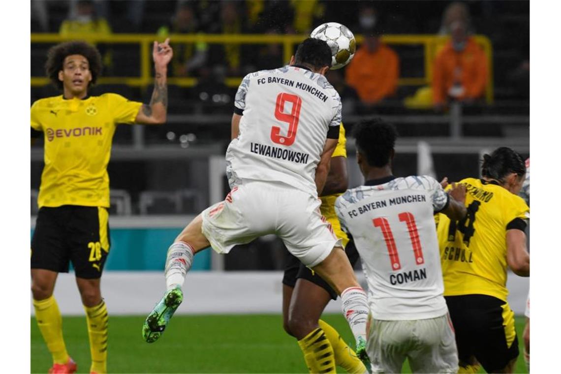 Bayern-Stürmer Robert Lewandowski (M) sorgt per Kopfball für die Führung in Dortmund. Foto: Bernd Thissen/dpa