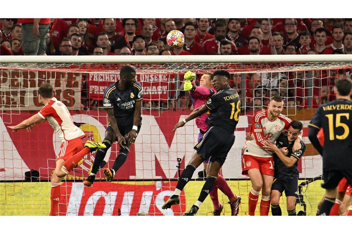 Bayern-Torhüter Manuel Neuer (M.) faustet den Ball aus der Gefahrenzone.