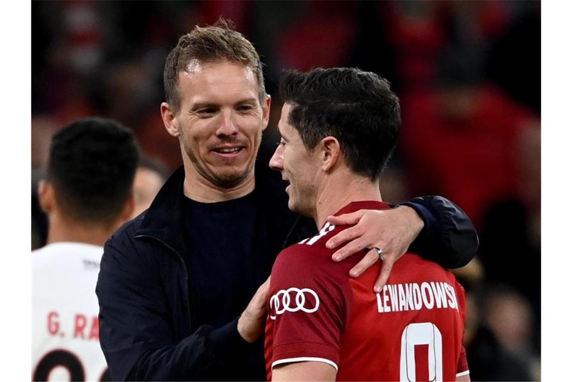 Bayern-Trainer Julian Nagelsmann (l) gratuliert Robert Lewandowski zum dessen drei Treffern. Foto: Sven Hoppe/dpa