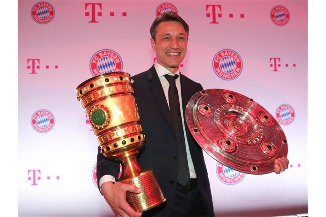 Bayern-Trainer Niko Kovac hält mit dem DFB-Pokal und Meisterschale. Foto: Alexander Hassenstein/Bongarts/Getty Images/Pool