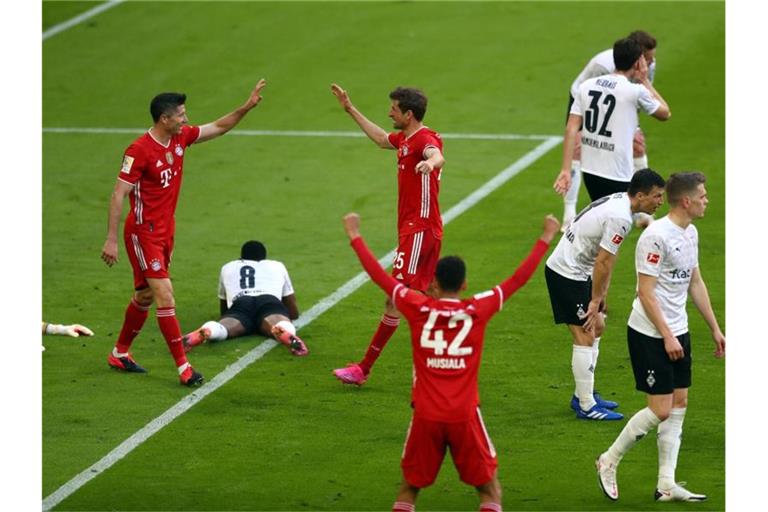 Bayern-Urgestein Thomas Müller (M) bejubelt sein Tor zum 2:0 mit Robert Lewandowski und Jamal Musiala. Foto: Matthias Schrader/AP-Pool/dpa