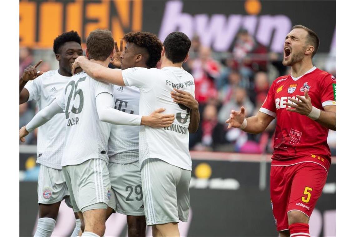 Bayerns Alaba (l-r), Müller, Coman und Lewandowski feiern das 2:0. Kölns Czichos (r) schreit und ärgert sich. Foto: Federico Gambarini/dpa