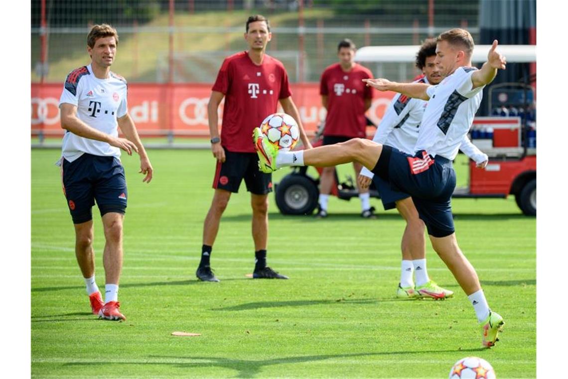 Bayerns Joshua Kimmich (r), Leroy Sane (hinten) und Thomas Müller halten den Ball hoch. Co-Trainer Dino Toppmöller beobachtet das Warm-Up. Foto: Matthias Balk/dpa