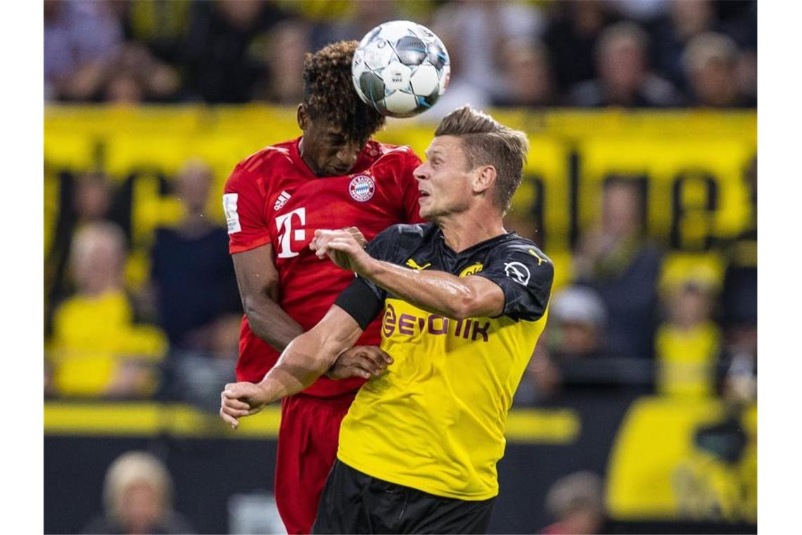 Bayerns Kingsley Coman (l) und Dortmunds Lukasz Piszczek im Kopfballduell. Foto: Guido Kirchner