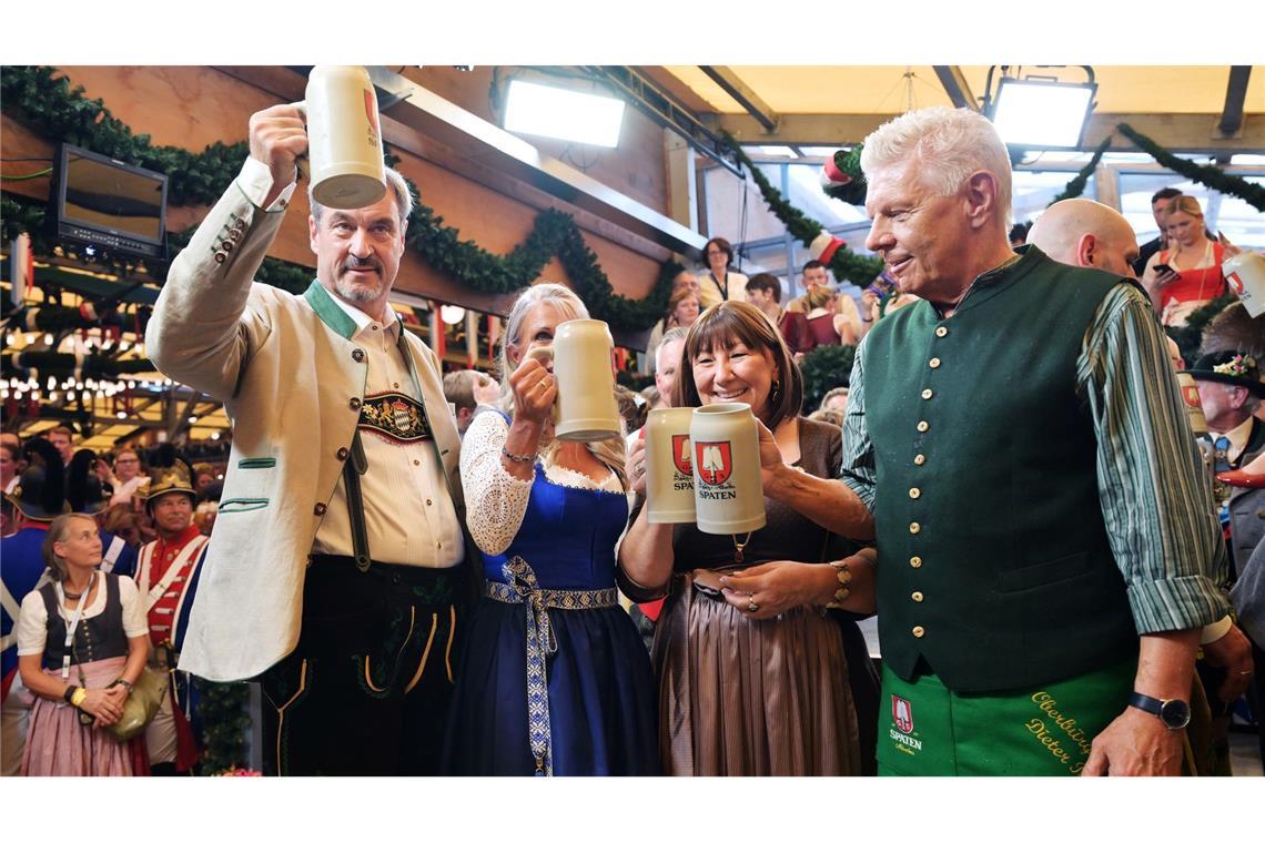 Bayerns Ministerpräsident Söder (l.) und Münchens OB Reiter (r.) stoßen mit ihren Ehefrauen auf eine friedliche Wiesn an.