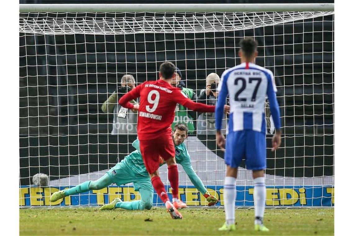 Bayerns Robert Lewandowski (l) verwandelt einen Elfmeter zum 2:0. Foto: Andreas Gora/dpa
