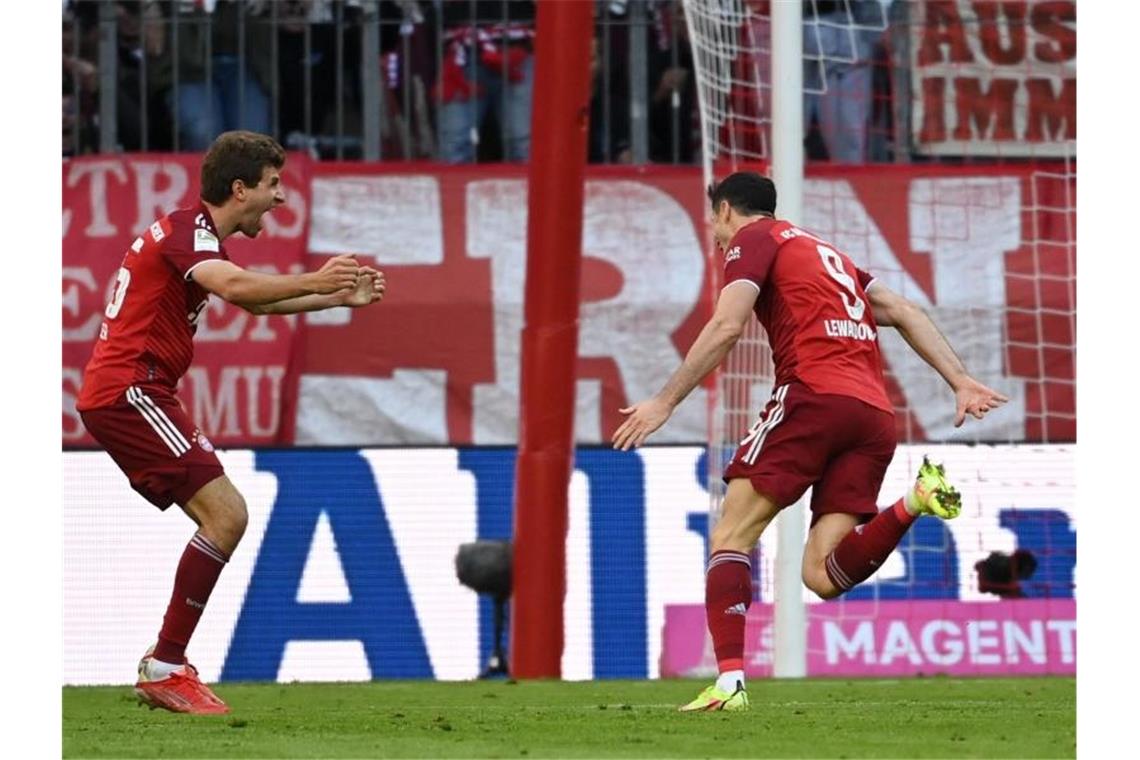 Bayern bleiben souverän - Debatte über Kimmichs Impfstatus Bayerns Robert Lewandowski (r) jubelt mit Thomas Müller nach seinem Treffer. Foto: Sven Hoppe/dpa