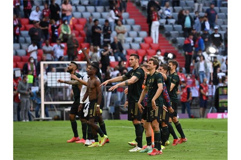 Bayerns Spieler feiern nach der fulminanten Partie den Sieg gemeinsam mit den Fans. Foto: Sven Hoppe/dpa