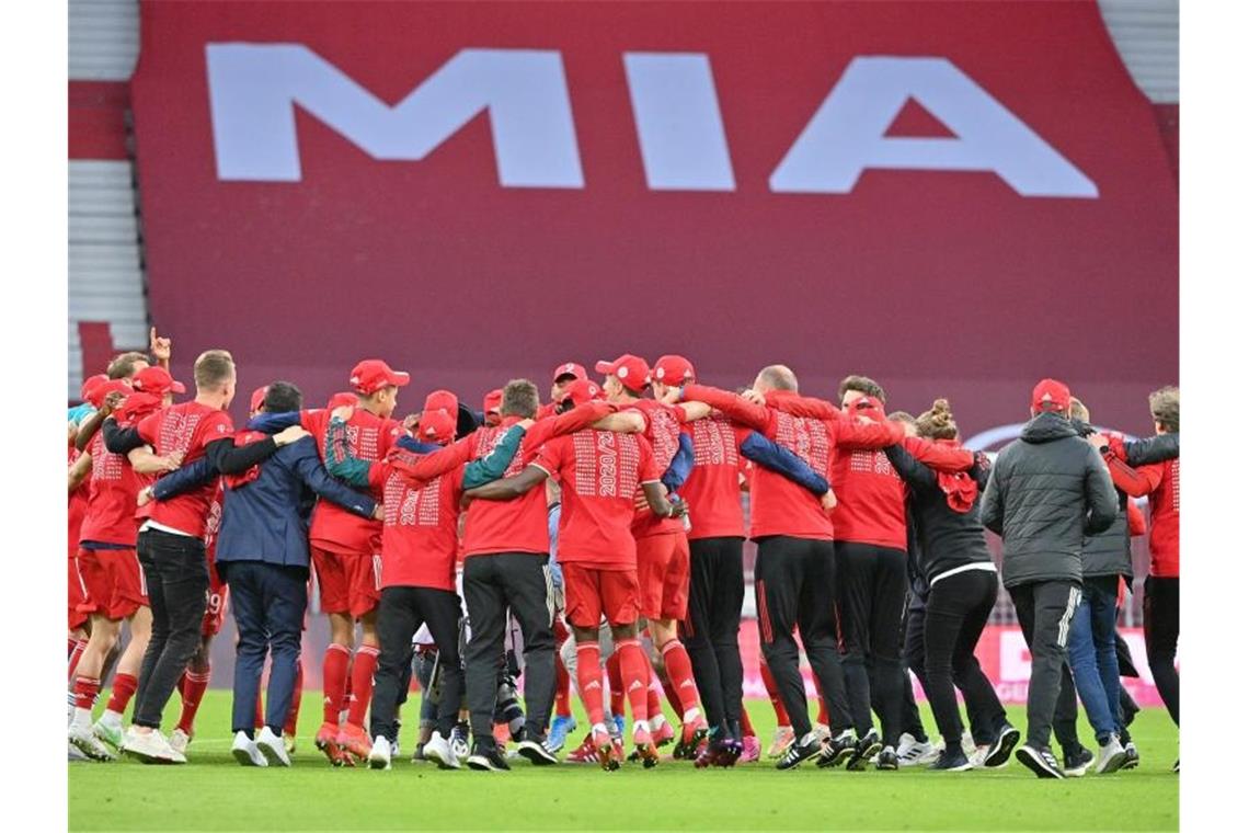 Bayerns Spieler feiern nach Spielende die Deutsche Meisterschaft auf dem Rasen der leeren Allianz Arena. Foto: Peter Kneffel/dpa-Pool/dpa