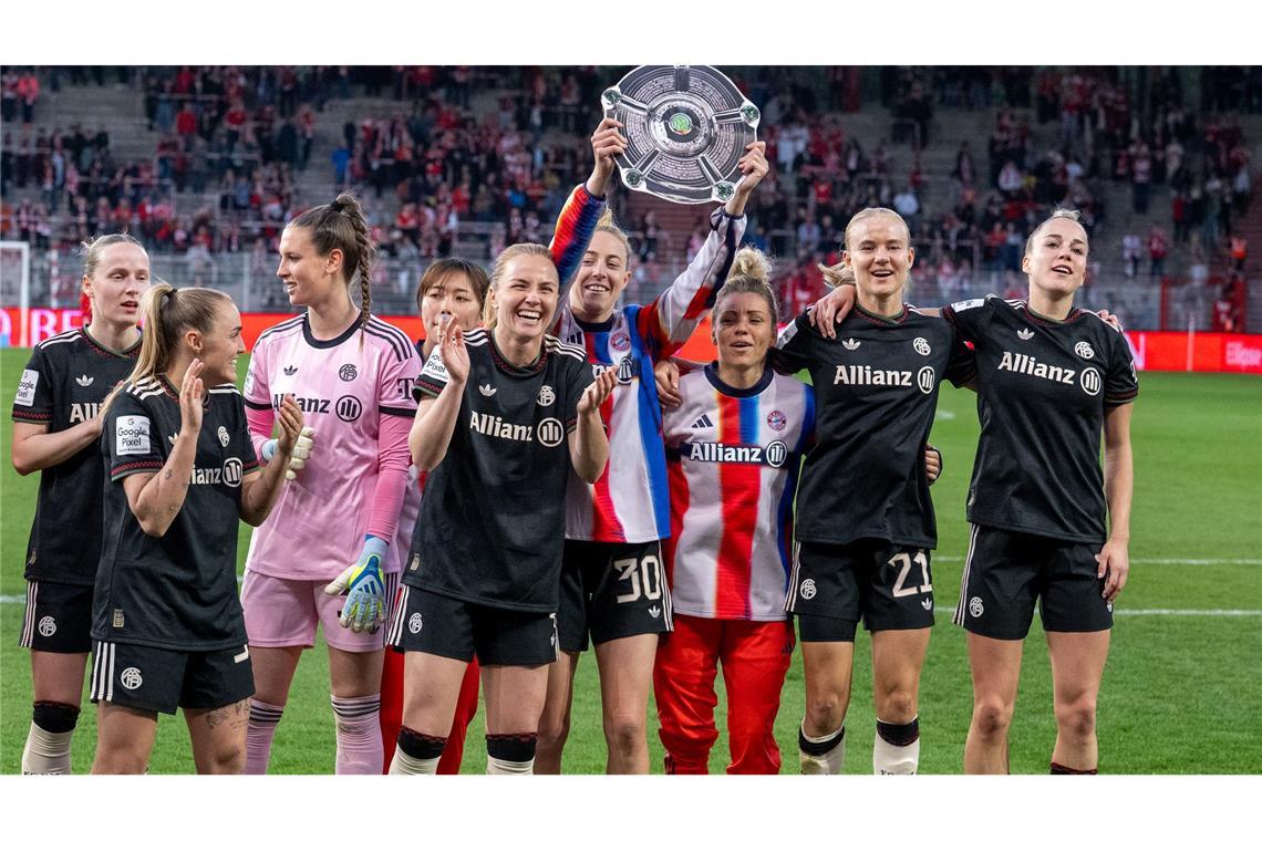 Bayerns Spielerinnen jubeln nach Spielende gegen den 1. FC Union Berlin mit der Nachbildung einer Meisterschale über den Sieg.