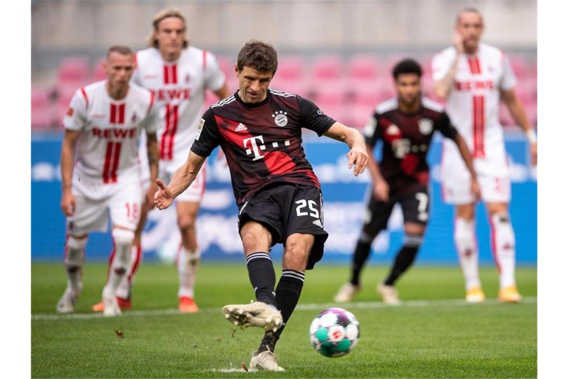 Bayerns Thomas Müller trifft per Strafstoß zur 1:0-Führung in Köln. Foto: Marius Becker/dpa-Pool/dpa