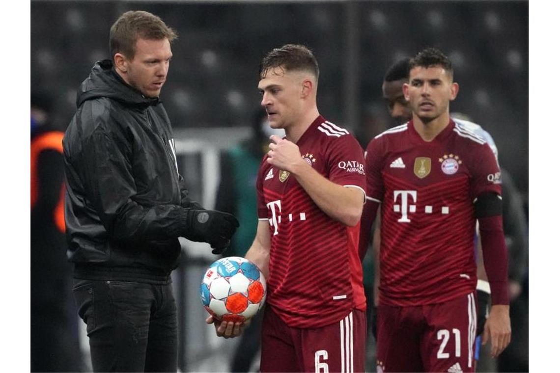 Bayerns Trainer Julian Nagelsmann (l) spricht nach der Partie in Berlin mit Joshua Kimmich. Foto: Soeren Stache/dpa-Zentralbild/dpa