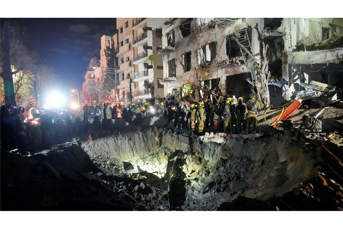 Beamte des israelischen Heimatfrontkommandos durchsuchen die Trümmer eines beschädigten Wohnhauses.