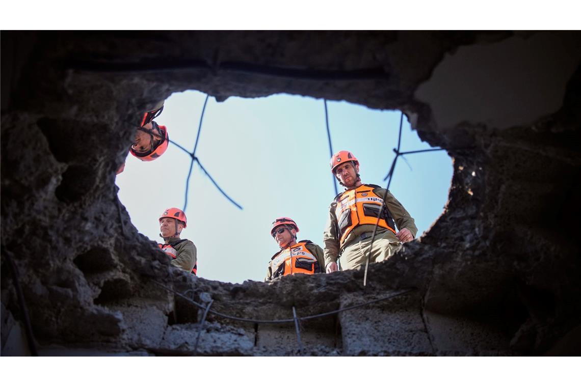 Beamte des israelischen Heimatfrontkommandos inspizieren ein beschädigtes Wohnhaus nach einem iranischen Raketenangriff in der israelischen Stadt Petach Tikwa.