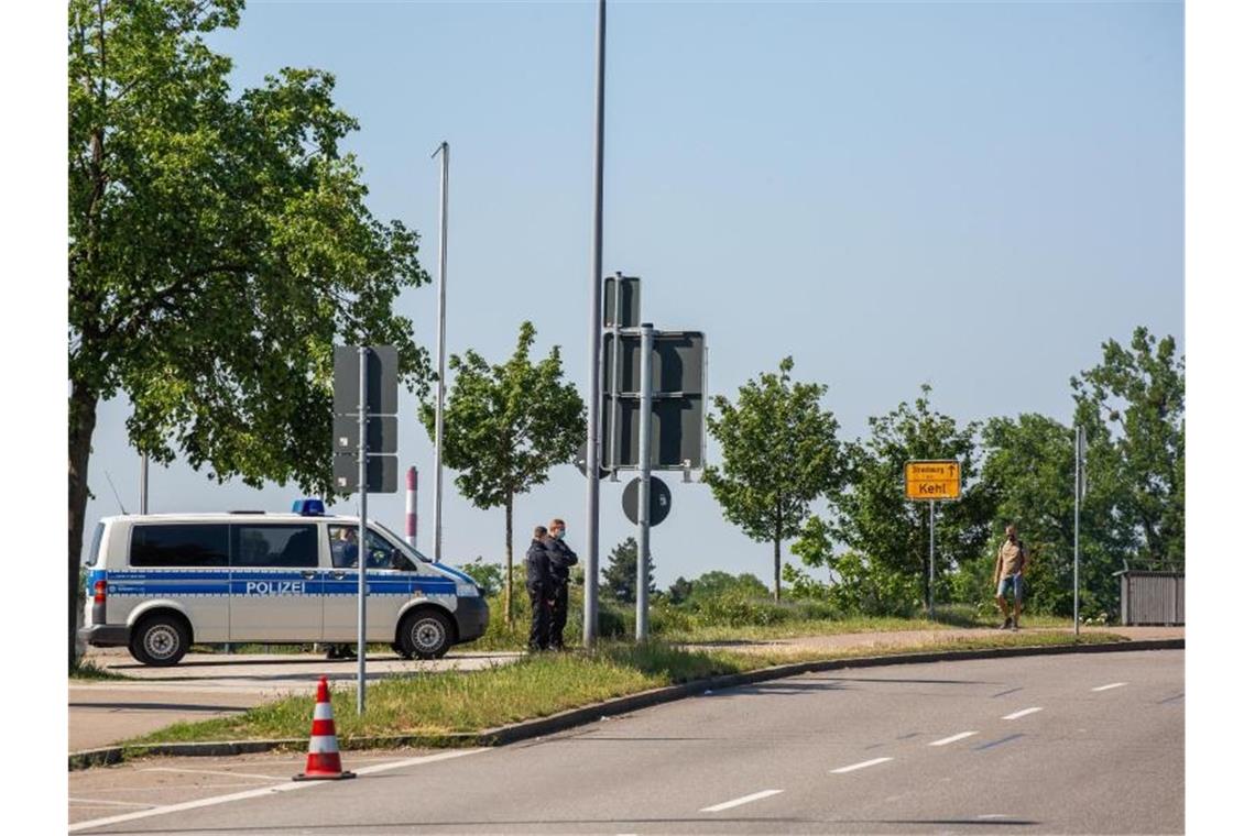 Beamte und ein Einsatzfahrzeug der Bundespolizei nahe einer Brücke am Grenzübergang nach Frankreich. Foto: Philipp von Ditfurth/dpa