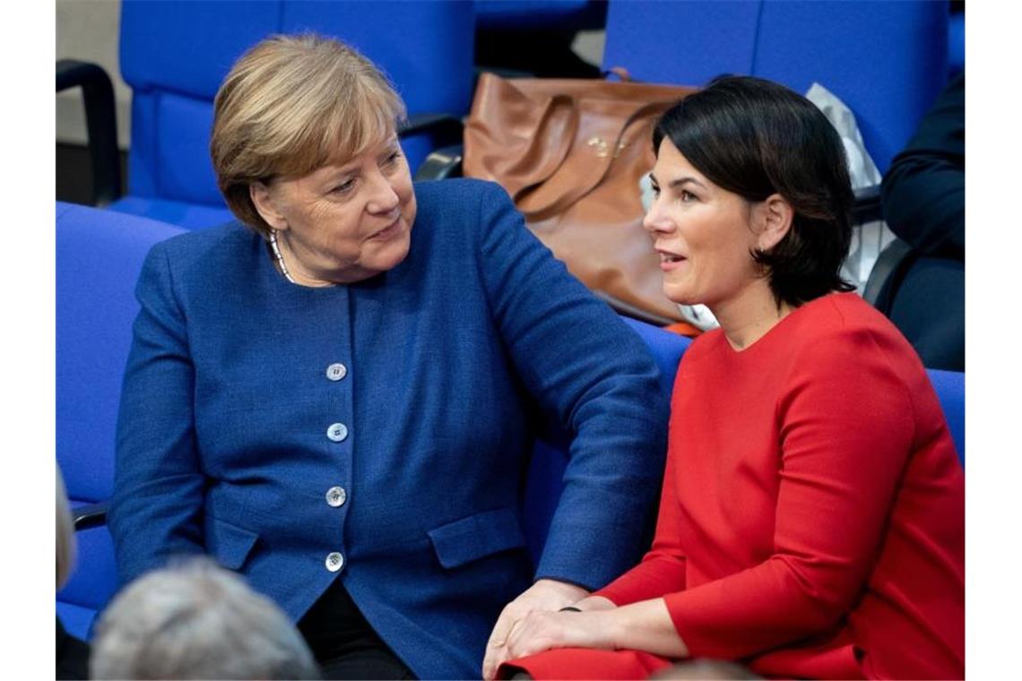 Begegnung im Bundestag: Bundeskanzlerin Angela Merkel (l, CDU) und Annalena Baerbock, Bundesvorsitzende von Bündnis 90/Die Grünen, während einer Sitzung zu Jahresbeginn. Foto: Kay Nietfeld/dpa