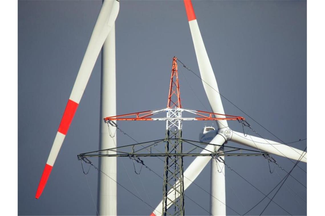 Bei den Energiekosten ist für die Haushalte in Deutschland keine Entlastung in Sicht - obwohl der Bund viele Milliarden Euro in die Deckelung der EEG-Umlage steckt. Windräder und ein Strommast in Erkelenz. Foto: David Young/dpa