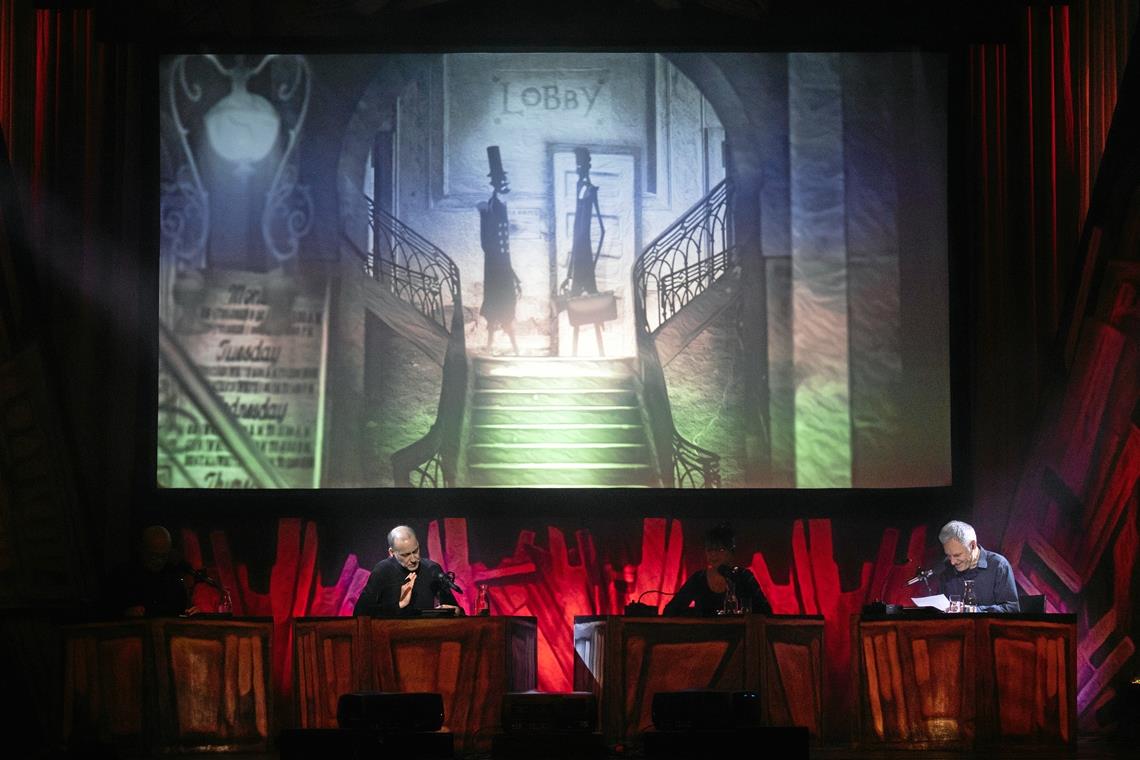 Dr. Jekyll und Mr. Hyde auf der Leinwand in Backnang Bei der Aufführung saßen eine Schauspielerin und drei Schauspieler mit Mikrofonen ausgestattet an vier Pulten vor der Leinwand. Foto: Alexander Becher