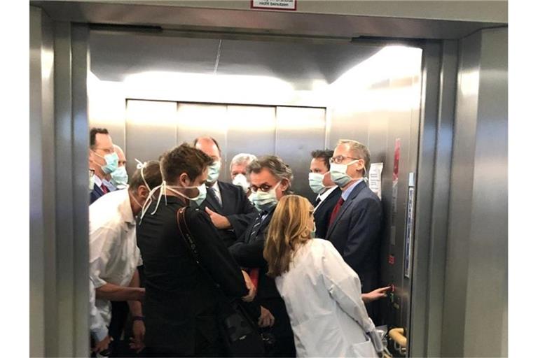 Bei einem Besuch der Uniklinik Gießen drängen sich Bundesgesundheitsminister Spahn (CDU, l), und Hessens Ministerpräsident Bouffier (CDU, M) mit Begleitern im Fahrstuhl. Foto: Bodo Weissenborn/Hessischer Rundfunk/dpa