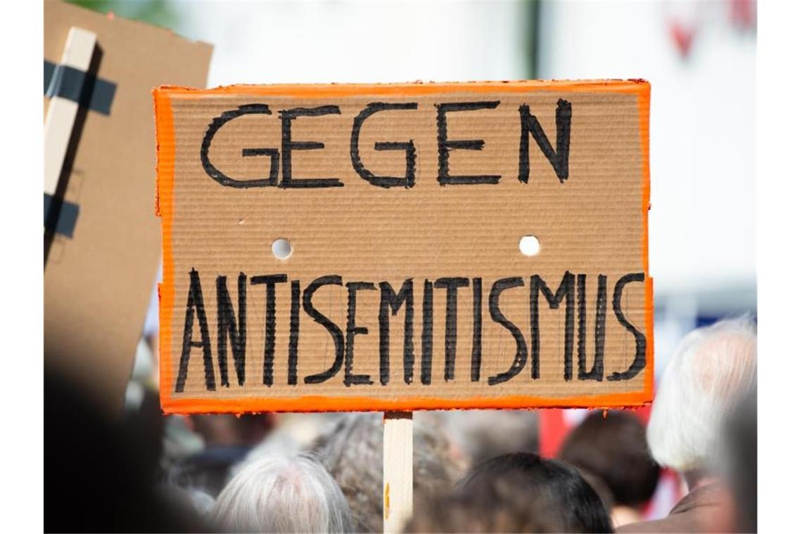 Antisemitische Straftaten sollen präziser erfasst werden Bei einer Demo wird ein Schild gegen Antisemitismus in die Höhe gehalten. Die Erfassung antisemitischer Straftaten soll verbessert werden. Foto: Christophe Gateau/dpa