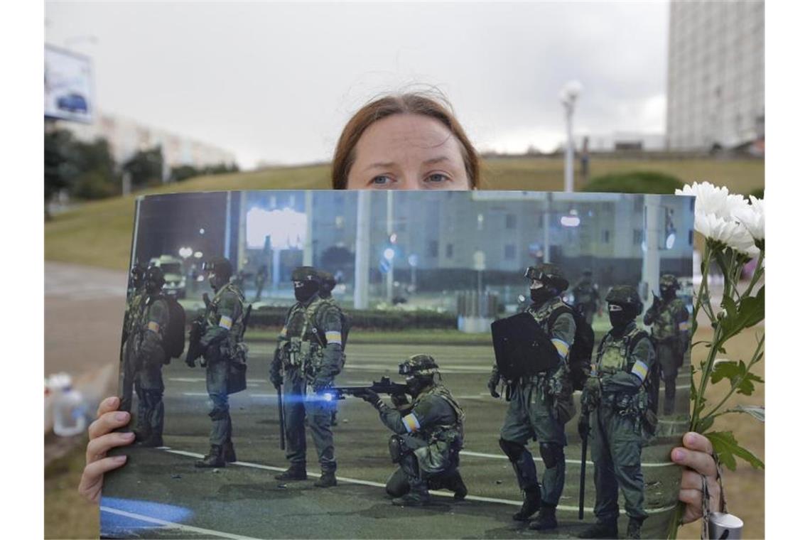 Kreml warnt Belarus vor „Abnabeln von Russland“ Bei einer Demonstration in Minsk präsentiert eine Frau ein Foto der gegen die Protestbewegung eingesetzten Sicherheitskräfte. Foto: Dmitri Lovetsky/AP/dpa