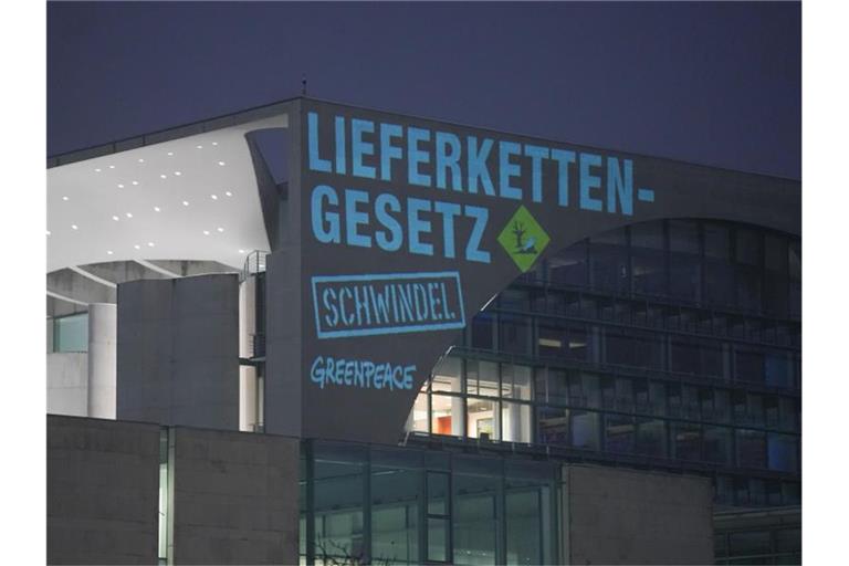 Bei einer Greenpeace-Aktion zum Lieferkettengesetz wird der Spruch „Lieferkettengesetz. Schwindel“ an die Außenfassade des Bundeskanzleramts projiziert. Foto: Jörg Carstensen/dpa