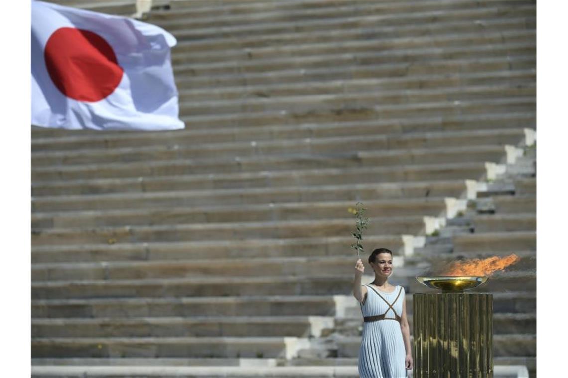 Bei einer kleinen Feier wird das olympische Feuer an die Organisatoren der Sommerspiele von Tokio 2020 übergebe. Foto: Aris Messinis/AFP POOL/AP/dpa