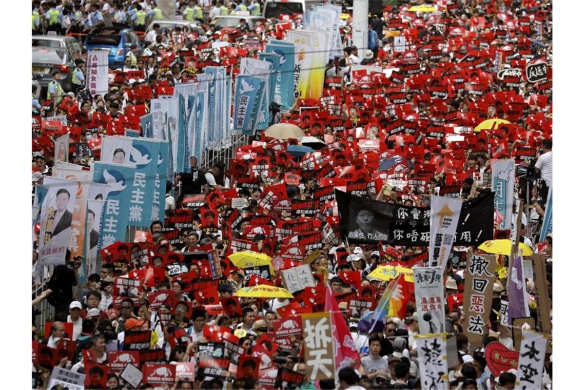 Bei einer Massen-Kundgebung in Hongkong tragen die Teilnehmer Fahnen und Plakate. Foto: Vincent Yu/AP