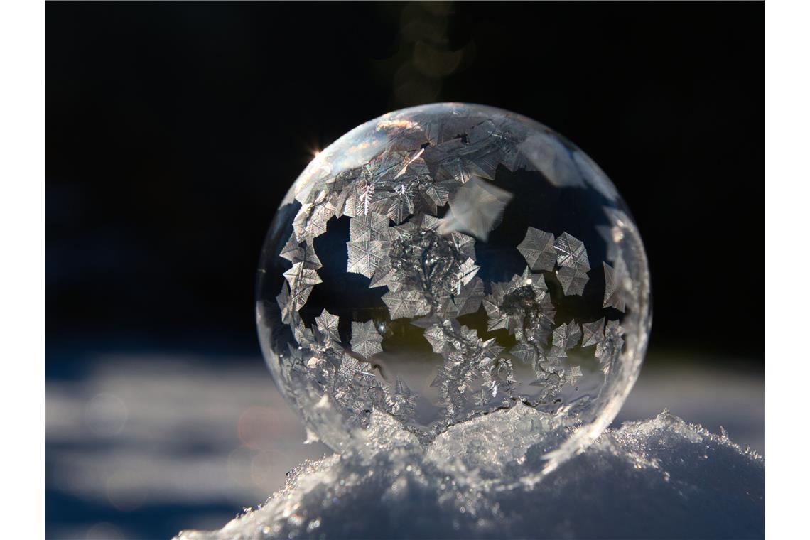 Bei eisigen Temperaturen bilden sich schnell Eiskristalle auf der Seifenblase vo...