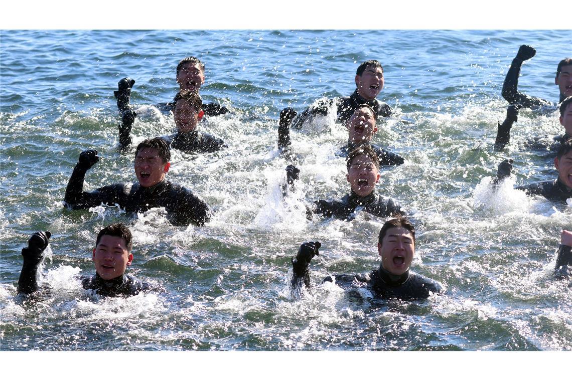 Bei Minusgraden singen Taucher der südkoreanischen Marine, während sie im eiskalten Meerwasser vor der Stadt Changwon schwimmen.