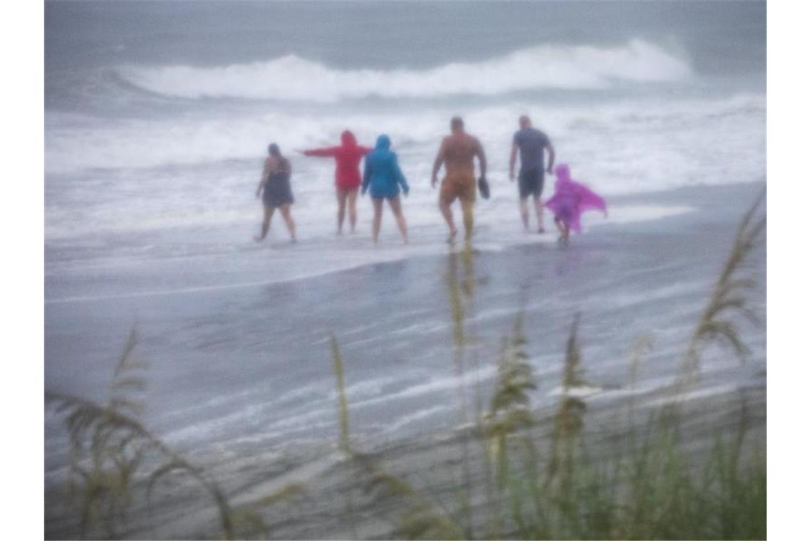 Tropensturm „Isaias“ fegt über US-Ostküste - drei Tote Bei stürmischem Wetter stehen Menschen am Strand der bei Urlaubern beliebten Stadt Myrtle Beach in North Carolina. Foto: Jason Lee/The Sun News/AP/dpa
