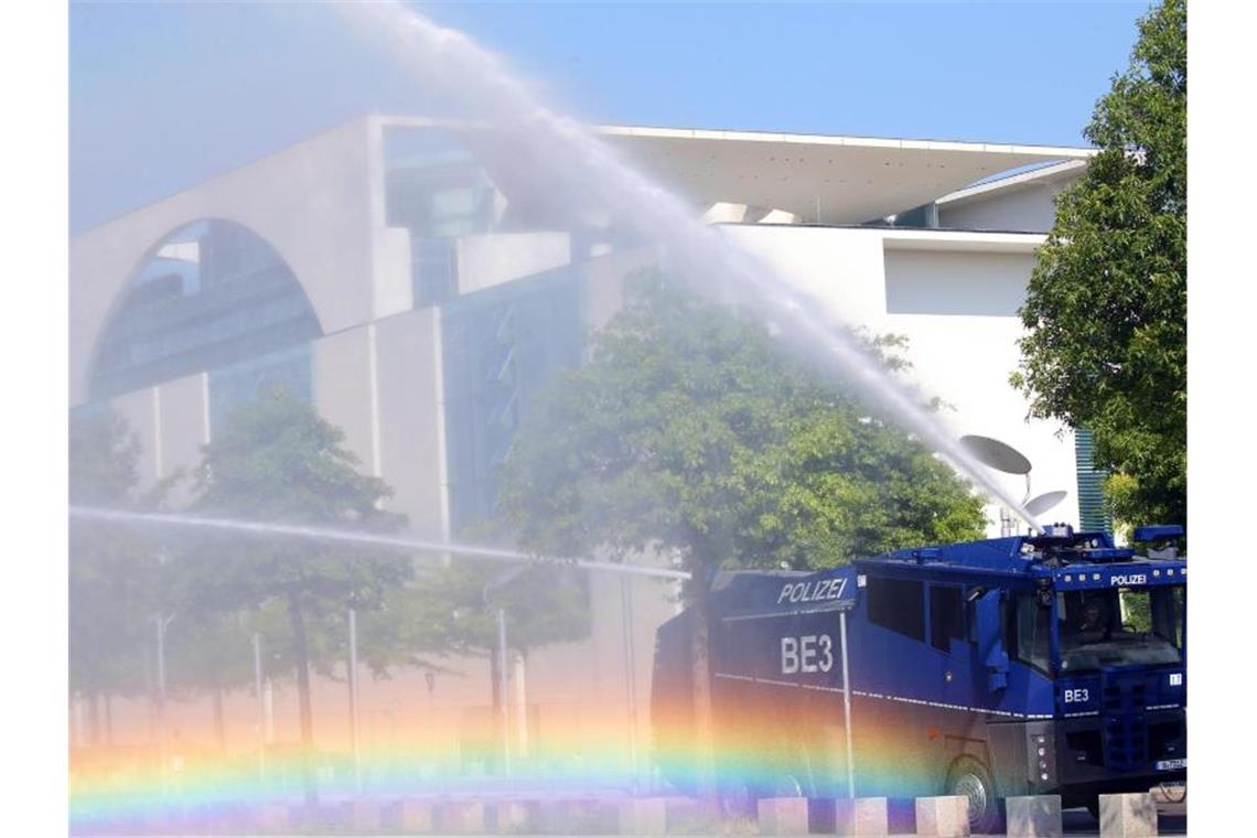 Bei Temperaturen um 30 Grad und extremer Trockenheit bewässert ein Wasserwerfer der Polizei die Grünanlagen vor dem Bundeskanzleramt. Foto: Wolfgang Kumm