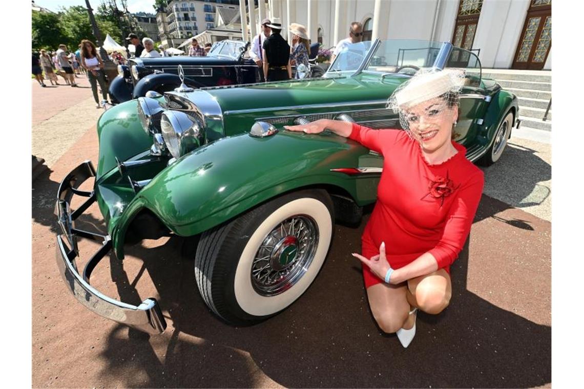 Besucher bestaunen Oldtimer in Baden-Baden Beim 44. Internationalen Oldtimer-Meeting sitzt Bianca Biehl an einem Mercedes-Benz Replika 540 K. Foto: Uli Deck/dpa