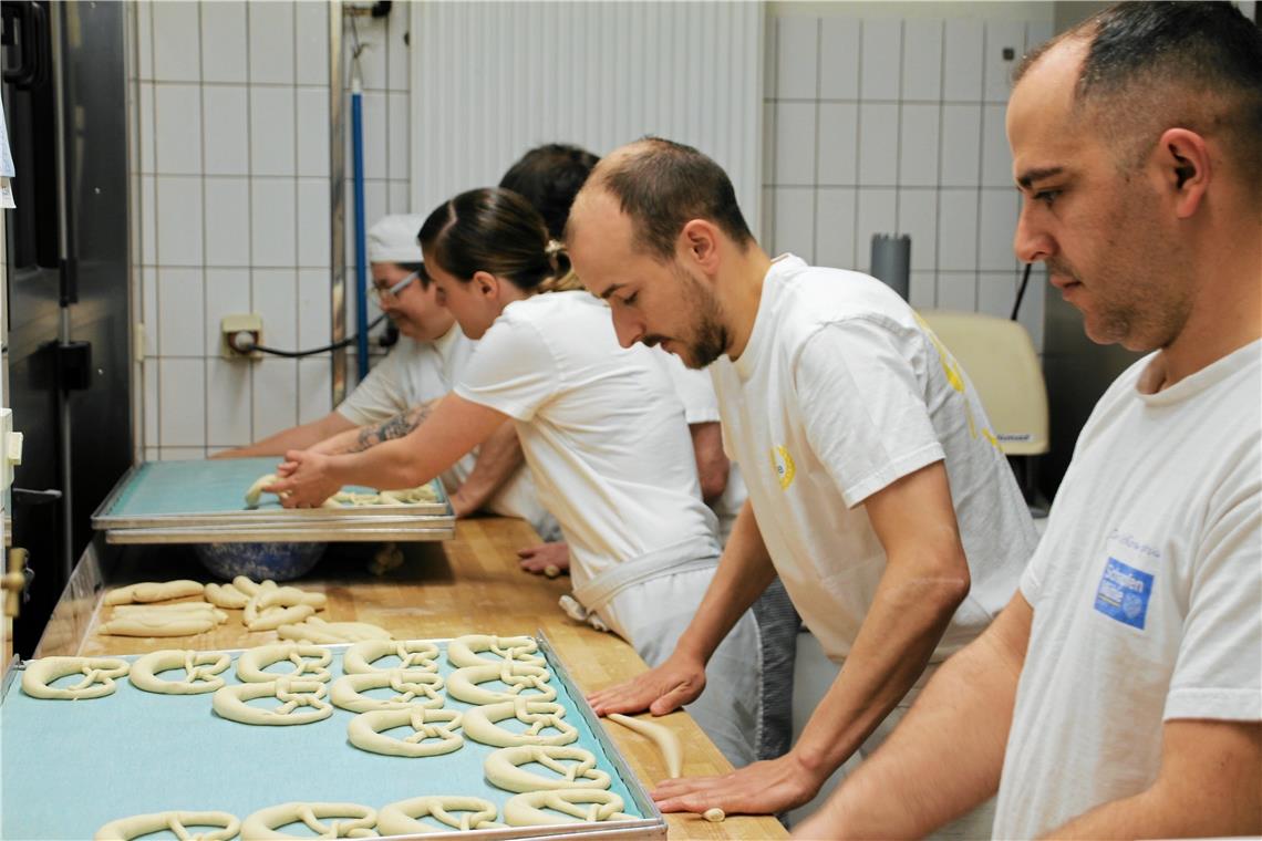 Vom Teigling zur Brezel Beim Brezelschlingen ist jede Hand gefragt. Für Bardhyl Delijaj, Marco Müller, Kim Müller, Uwe Müller (verdeckt) und Claudia Fenger (von rechts) ist die Arbeit Routine.