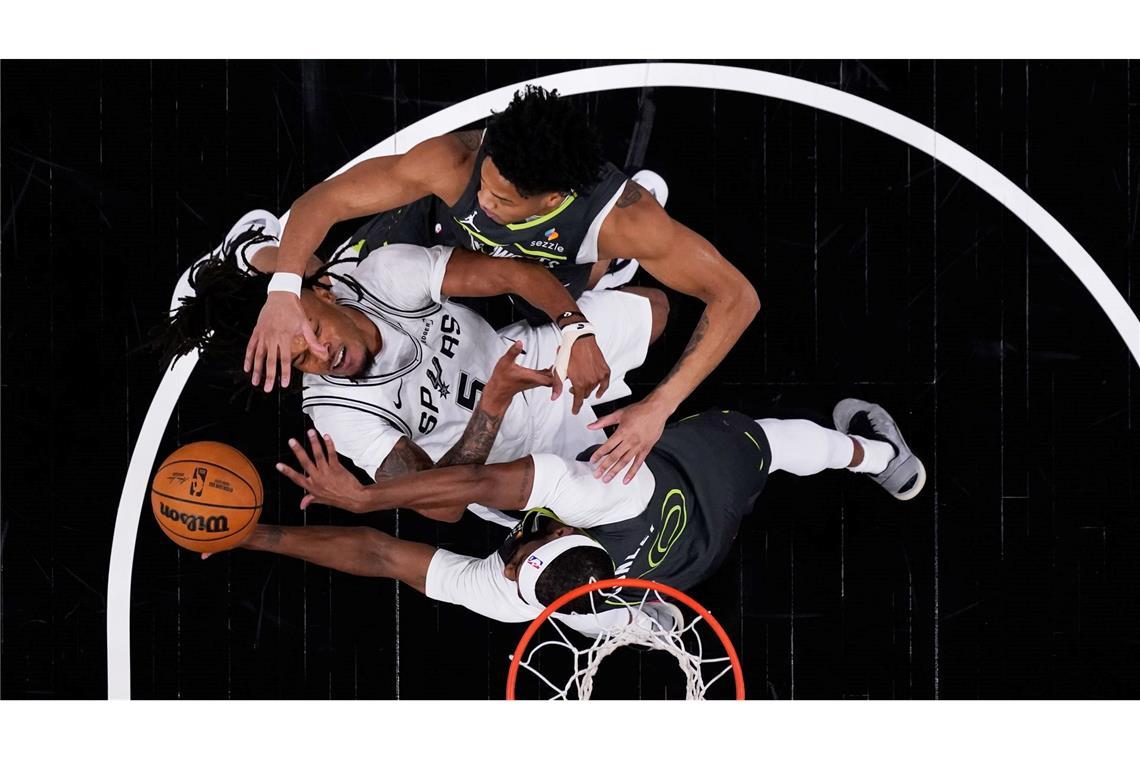 Beim NBA-Spiel der San Antonio Spurs gegen die Minnesota Timberwolves wird Stephon Castle (l) von den Spurs von Mike Conley von den Timberwolves geblockt.
