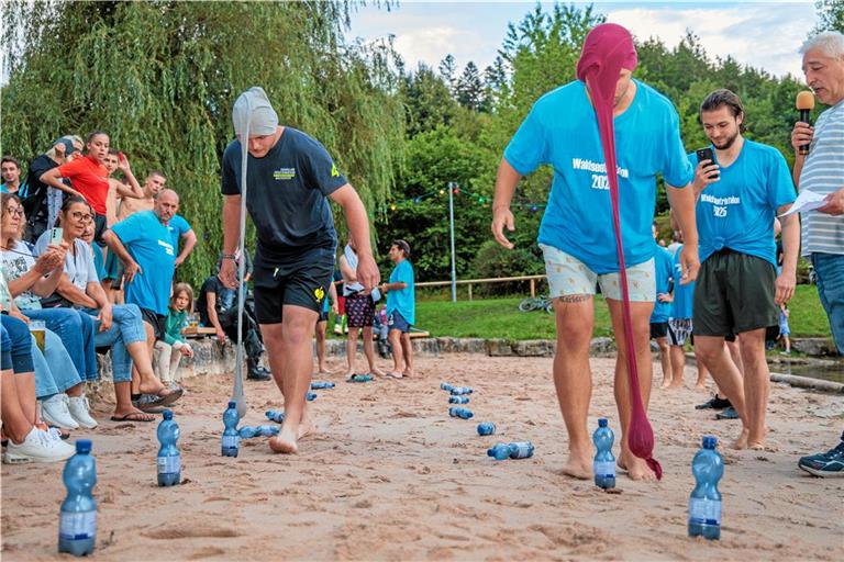 Beim „Strumpfkegeln“ müssen die Teilnehmenden des Waldseetriathlons Flaschen umwerfen – und zwar mit Gewichten, die in den Beinen einer Strumpfhose von ihrem Kopf herunterhängen. Fotos: Stefan Bossow